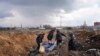 Dead bodies are put into a mass grave on the outskirts of Mariupol, Ukraine, Wednesday, March 9, 2022, as people cannot bury their loved ones because of the heavy shelling by Russian forces. (AP Photo/Evgeniy Maloletka)