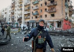 Seorang petugas polisi menjaga area di sekitar rumah yang hancur akibat penembakan saat serangan Rusia di Ukraina berlanjut, di Kyiv, Ukraina, 14 Maret 2022. (Foto: REUTERS/Gleb Garanich)