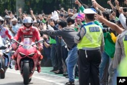 Pembalap Australia Jack Miller ikut berparade di Jakarta, Rabu, 16 Maret 2022. Indonesia akan menggelar Moto GP di Mandalika, Pulau Lombok, 18-20 Maret.(AP Photo/Achmad Ibrahim)