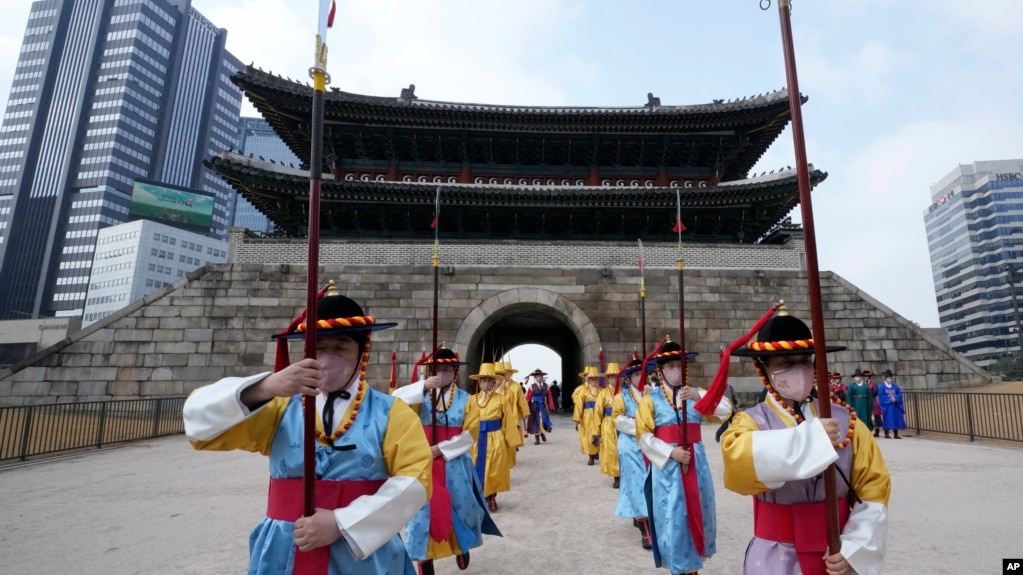 Performers wearing face masks during ceremonies at the Sungnyemun Gate in Seoul, South Korea, March 15, 2022. South Korea had its deadliest day yet of the pandemic recently with a record increase in infections driven by Omicron variant. (AP Photo/Ahn Young-joon)