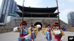 Performers wearing face masks during ceremonies at the Sungnyemun Gate in Seoul, South Korea, March 15, 2022. South Korea had its deadliest day yet of the pandemic recently with a record increase in infections driven by Omicron variant. (AP Photo/Ahn Young-joon)