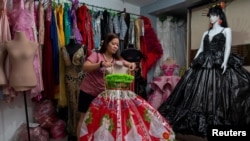 Leonora Buenviaje memajang gaun dari karung beras dan kantong plastik bekas, di tokonya di Cainta, Provinsi Rizal, Filipina, 3 Maret 2022. (REUTERS/Lisa Marie David)