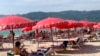 Tourists lounge under umbrellas along Patong Beach in Phuket, Thailand, March 11, 2022. 