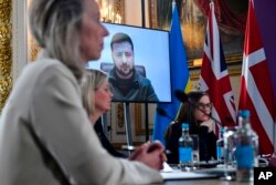 Ukrainian President Volodymyr Zelensky addresses by video link leaders attending a meeting of the leaders of the the Joint Expeditionary Force (JEF), a coalition of 10 states focused on security in northern Europe, in London, Tuesday, March 15, 2022. (Justin Tallis/Pool Photo via AP)