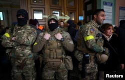 FILE - Foreign fighters from the UK asked to be identified as "Scouser," "Jacks" and "Ben Grant" pose for a picture as they are ready to depart toward the front line in the east of Ukraine following the Russian invasion, at the main train station in Lviv, Ukraine, March 5, 2022.