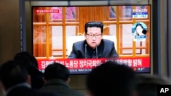 People watch a TV showing a file image of North Korean leader Kim Jong Un shown during a news program at the Seoul Railway Station in Seoul, South Korea, Jan. 20, 2022.