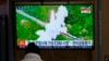 A visitor watches a TV screen showing a news program reporting about North Korea's missile with file footage at a train station in Seoul, South Korea, Friday, March 11, 2022. (AP Photo/Lee Jin-man)