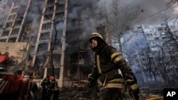 Vatrogasci pokušavajju da ugase požar u zgradi u Kijevu posle ruskog napada (Foto: AP/Vadim Ghirda)