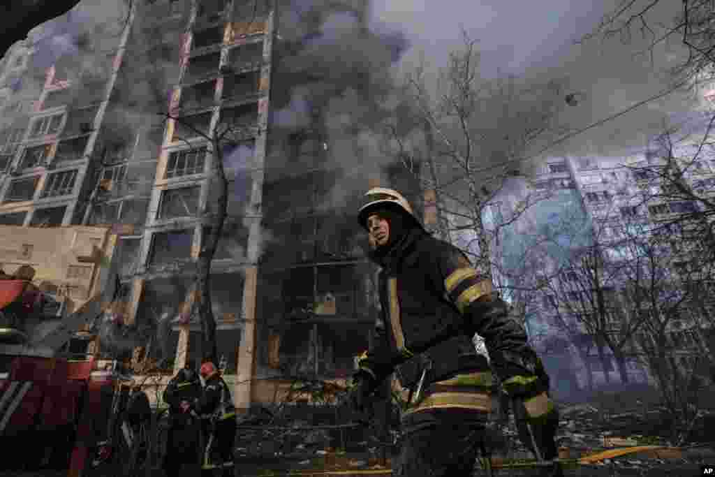 Un bombero camina fuera de un edificio de apartamentos destruido después de un bombardeo en un área residencial en Kiev, Ucrania.