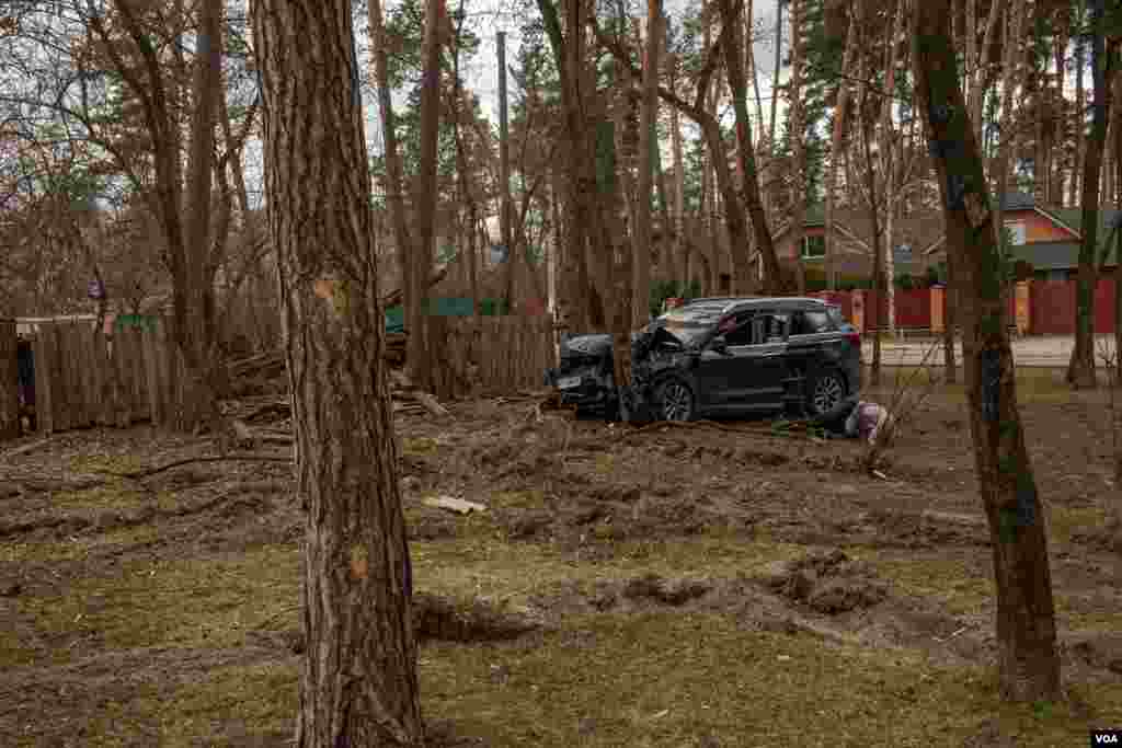 The body of a man is seen on the ground at a park, while Russian and Ukrainian soldiers fight in a nearby forest, in Irpin, Ukraine, March 13, 2022.