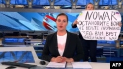 A video grab shows Russian Channel One editor Marina Ovsyannikova holding a poster that reads "Stop the war. Don't believe the propaganda. They are lying to you here" during a live evening news broadcast, in Moscow, March 14, 2022.