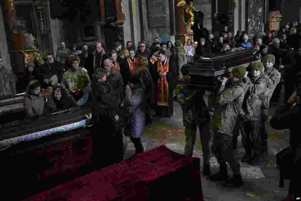 Ukrainian soldiers carry the coffin of one of the military servicemen, who were killed during an airstrike on a military base in Yarokiv, during a funeral ceremony in Lviv, March 15, 2022.