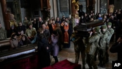 资料照片：乌克兰军人在利沃夫的葬礼上抬着在俄军空袭乌军基地时丧生的一名乌克兰军人的灵柩。(2022年3月15日)
