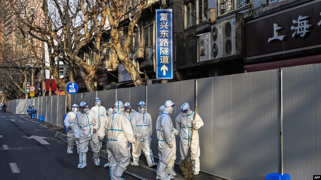 Obreros en ropas de protección trabajan en un área de la ciudad china de Shanghái donde se registraron nuevos casos de COVID-19 el 15 de marzo de 2022.