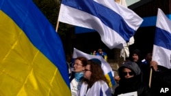 Russian protesters living in Cyprus wave Ukrainian and Russian national flags without the red stripe, during a protest against Russia's invasion of Ukraine, in southern port city of Limassol, Cyprus, March 13, 2022.