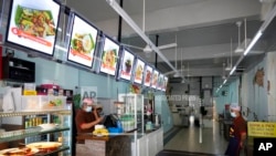 File -Restaurant staffs wearing face mask wait for customers in Kuala Lumpur, Malaysia, June 28, 2021.