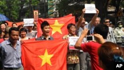 Protesters shout their slogan to protest against China while marching in Hanoi, Vietnam, Sunday, July 17, 2011.