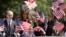 U.S. First Lady Melania Trump and Philip May, the husband of British Prime Minister Theresa May stand with school children during a visit to British military veterans known as "Chelsea Pensioners" at The Royal Hospital Chelsea in central London Friday, July 13, 2018.