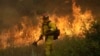 A firefighter with Cal Fire Mendocino Unit walks along a containment line as a wildfire advances, July 30, 2018, in Lakeport, California.