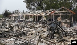 The charred remains of an apartment complex remain that burned from a wildfire two days earlier, Sept. 14, 2015, in Middletown, Calif.