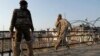A Kashmiri civilian walks past an Indian policeman standing near a barbed wire during curfew in Srinagar, India, February 9, 2013.