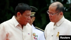 Incoming President Rodrigo Duterte (L) listens as outgoing President Benigno Aquino talks to him before Aquino leaves the Malacanang Palace in Manila, Philippines, June 30, 2016.