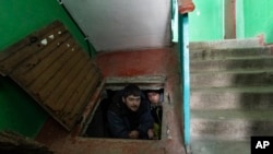 People hide in an improvised bomb shelter in Mariupol, Ukraine, March 12, 2022.