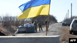 Servicemen of Ukrainian military forces guard a checkpoint, where they hold a position near Kharkiv, March 23, 2022.