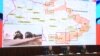 Russian officials hold a briefing on Russian military action in Ukraine, in Moscow on March 25, 2022. The screen shows the map of Ukraine.