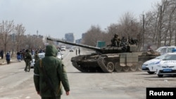 Service members of pro-Russian troops are seen atop of a tank on the outskirts of the besieged southern port city of Mariupol, Ukraine, March 20, 2022.
