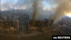 An aerial view shows smoke rising from damaged residential buildings following an explosion in Mariupol, Ukraine March 14, 2022 in this still image taken from a drone footage obtained from social media.