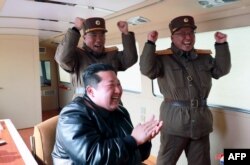 Esta fotografía tomada el 24 de marzo de 2022 y publicada por la Agencia Central de Noticias de Corea del Norte el 25 de marzo de 2022 muestra al líder norcoreano Kim Jong Un, en el centro, reaccionando durante la operación de lanzamiento de prueba de un nuevo tipo de balística intercontinental.