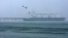 FILE - A seagull flies by a tanker near a liquefied natural gas plant on Sakhalin island outside the town of Korsakov, Russia, Feb. 16, 2009. France and nine other countries have asked the European Commission to propose stricter reporting obligations on Russian LNG.