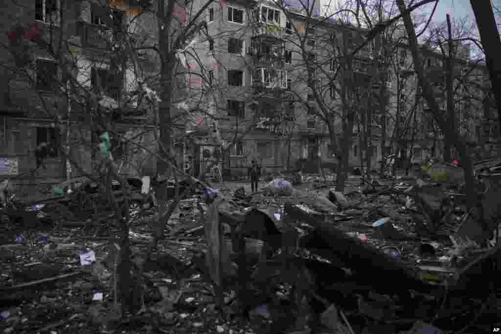 Un oficial de policía camina en el lugar de un bombardeo que dañó edificios residenciales en Kiev, Ucrania, el viernes 18 de marzo de 2022. Las fuerzas rusas intensificaron su asalto a las ciudades ucranianas el viernes, con nuevos ataques con misiles y bombardeos en los bordes de la capital, Kiev, y la ciudad occidental de Lviv, mientras los líderes mundiales presionaban para que se investigaran los repetidos ataques del Kremlin contra objetivos civiles, incluidas escuelas, hospitales y zonas residenciales.