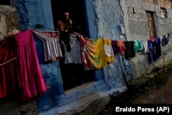 Rosivaldo Ferreira stands in the doorway of her home in the Bom Parto neighborhood of Maceio. She is waiting to be relocated, March 7, 2022. (AP Photo/Eraldo Peres)