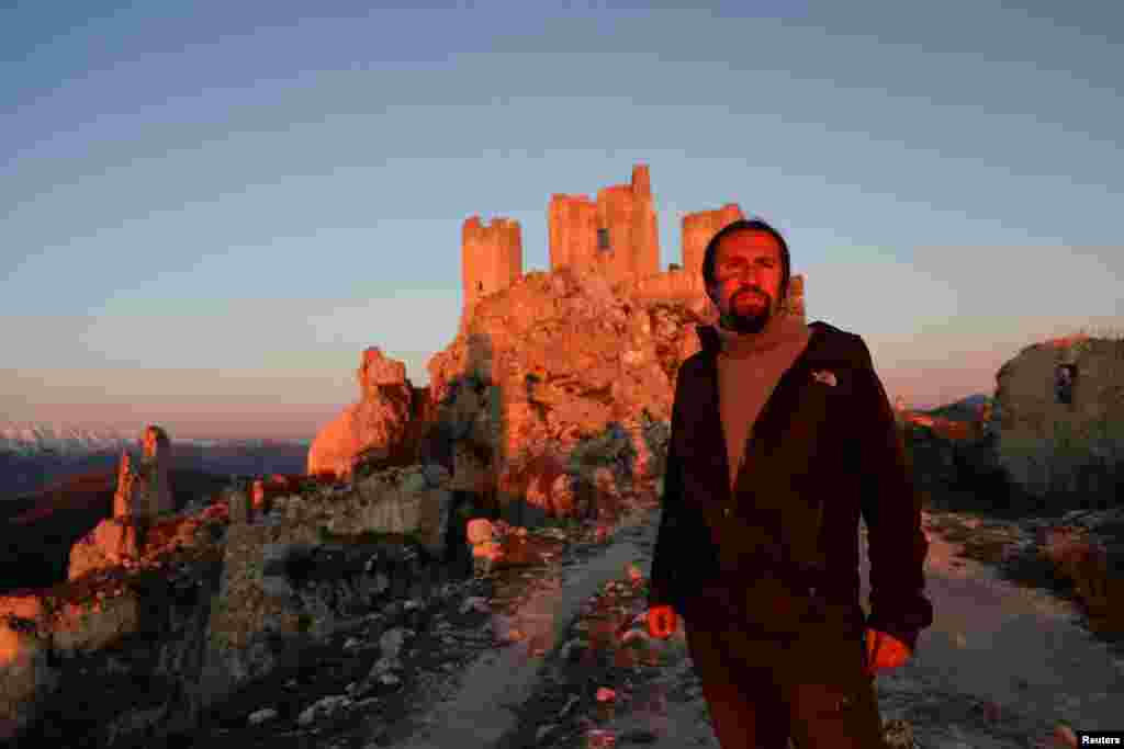 Franco Cagnoli, 39, caretaker of the Rocca Calascio castle, looks on in front of the castle situated at 1410 metres above sea level as the sun rises in the small village of Rocca Calascio, Italy, February 25, 2022. Italy counts about 1000 villages abandon