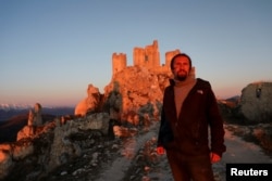 Franco Cagnoli, 39, caretaker of the Rocca Calascio castle, looks on in front of the castle in the small village of Rocca Calascio, Italy, February 25, 2022. (REUTERS/Antonio Denti)