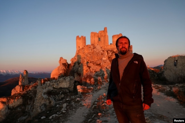 Franco Cagnoli, 39, caretaker of the Rocca Calascio castle, looks on in front of the castle in the small village of Rocca Calascio, Italy, February 25, 2022. (REUTERS/Antonio Denti)