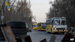 Evacuation buses carrying internally displaced people arrive at an IDP center in Zaporizhzhia, Ukraine, March 25, 2022.