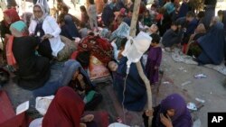 FILE- Internally displaced Afghan women from northern provinces, who fled their home due to fighting between the Taliban and Afghan security personnel, receive medical care in a public park in Kabul, Afghanistan, Aug. 10, 2021.