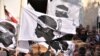 Mourners hold the 'A bandera testa mora', the flag of Corsica, as pallbearers carry the coffin of Corsican nationalist and convicted killer Yvan Colonna ahead of his funeral ceremony in Cargese, Corsica, on March 25, 2022. - 