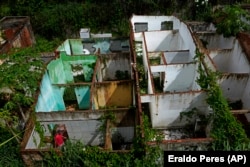 Paulo Sergio Doe visits abandoned homes in the Pinheiro neighborhood of Maceio, Alagoas state, Brazil, Sunday, March 6, 2022. (AP Photo/Eraldo Peres)