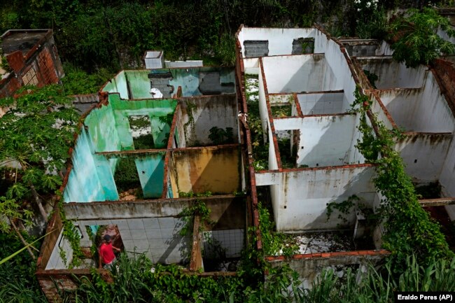 Paulo Sergio Doe visits abandoned homes in the Pinheiro neighborhood of Maceio, Alagoas state, Brazil, Sunday, March 6, 2022. (AP Photo/Eraldo Peres)