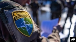 FILE - In this photo provided by the French army Friday March 18, 2022, a French soldier from the 7th Mountain Battalion wears a NATO badge at Amari air base, Estonia, Thursday, March 17, 2022.