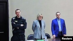 Russian opposition leader Alexei Navalny, accused of fraud and contempt of court, his lawyers Olga Mikhailova and Vadim Kobzev are seen on a screen via a video link during a court hearing at the IK-2 corrective penal colony in the town of Pokrov in Vladimir Region, Russia March 22, 2022. Navalny is already serving a two-and-a-half year sentence at a prison camp east of Moscow for parole violations.