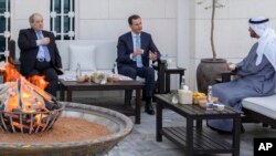 In this photo from the Facebook page of the Syrian presidency, Syrian President Bashar Assad, center, and Syrian Foreign Minister Faisal Mekdad, left, meet with Abu Dhabi's Crown Prince, Sheikh Mohammed bin Zayed Al Nahyan, in Abu Dhabi, United Arab Emirates, March 18, 2022.