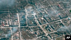 ယူကရိန်းနိုင်ငံ Mariupol မြို့က ပြဇာတ်ရုံနဲ့ တခြား အဆောက်အအုံတွေ မီးလောင် နေတဲ့ ပုံကို ၂၀၂၂ ခုနှစ် မတ်လ ၂၁ ရက်နေ့မှာ ရိုက်ယူ ထုတ်ပြန်ထားတဲ့ Maxar ဂြိုဟ်တု ဓာတ်ပုံ။