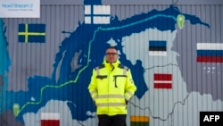 FILE - Axel Vogt, mayor of the German coastal resort town of Lubmin, northeastern Germany, stands in front of an information point container decorated with a map showing the Nord Stream 2 gas pipeline, which was expected to deliver Russian gas to European households, in Lubmin's industrial park, March 1, 2022.