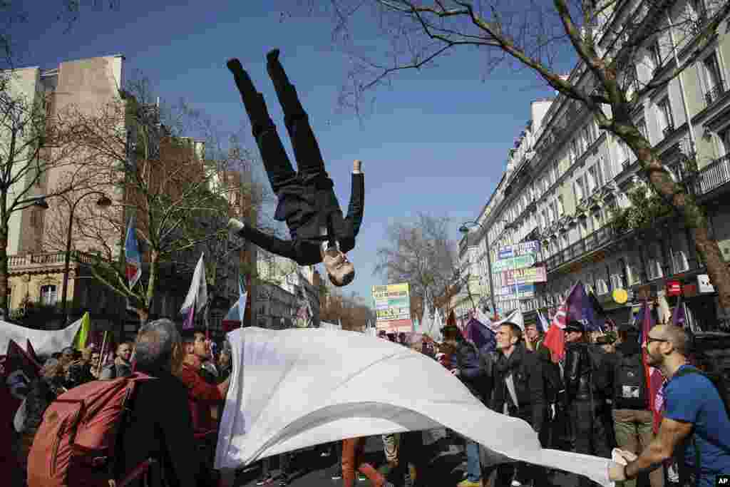 A puppet of French President Emmanuel Macron is tossed in the air during a march led by far-left candidate for the upcoming presidential election Jean-Luc Melenchon, in Paris.