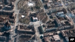 This satellite photo provided by Maxar Technologies March 19, 2022, shows the aftermath of an airstrike earlier in the week on the Mariupol Drama Theater, in Mariupol, Ukraine, and the area around it.